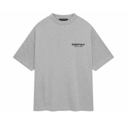 A light gray oversized short-sleeve t-shirt with 'ESSENTIALS' and 'CLEAR TO ALL' printed in black on the left chest, displayed on a solid white background.